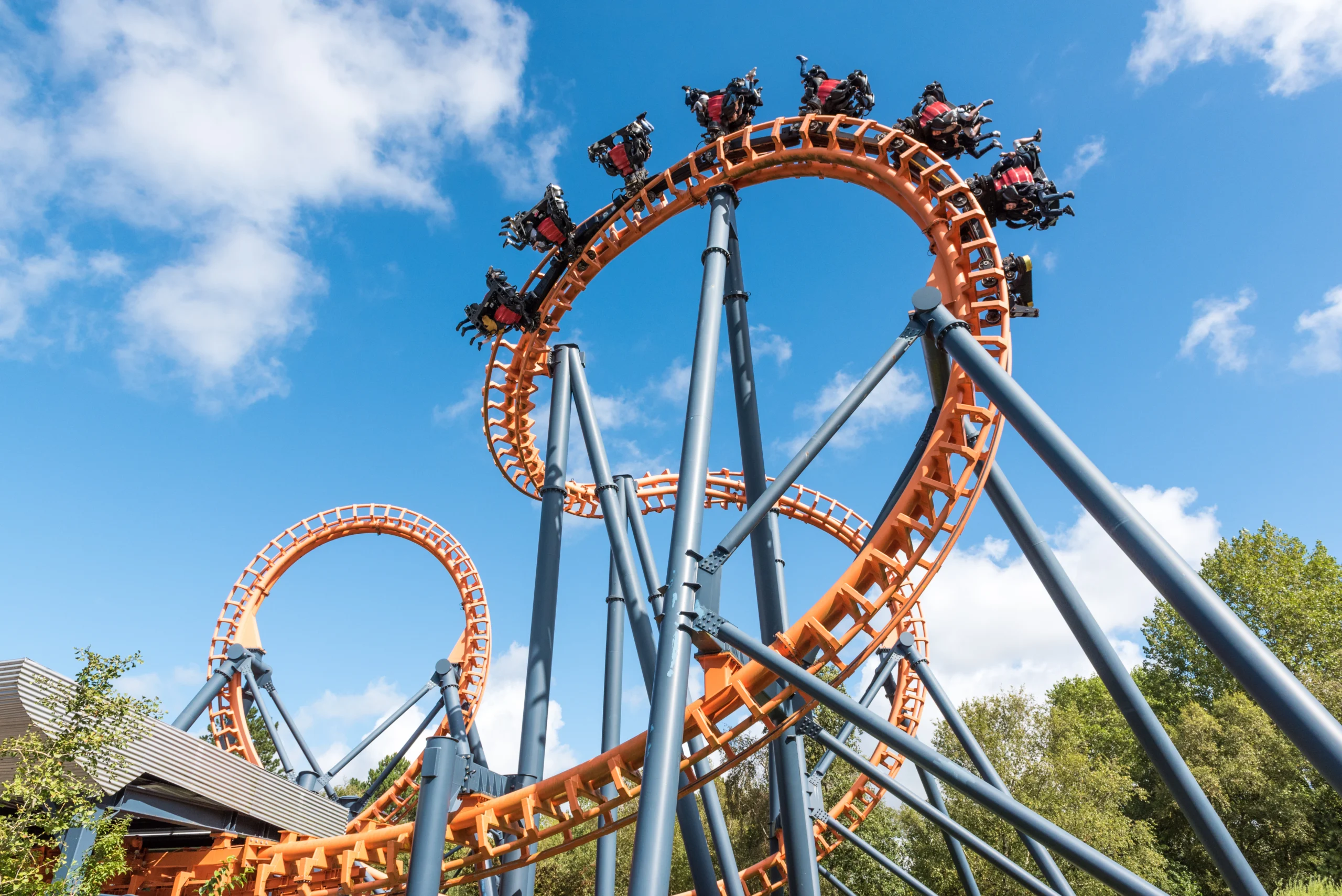 Ferris Wheel And Roller Coaster, France Looping orange roller coaster against a blue sky