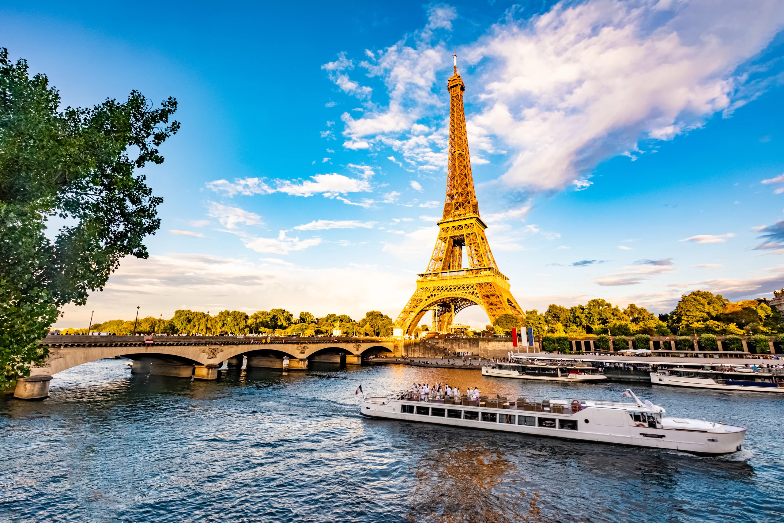 Scenic Panorama Of Eiffel Tower, Seine River, And Pont D’lena In Paris, France Eiffel Tower and a river cruise boat on the Seine in Paris