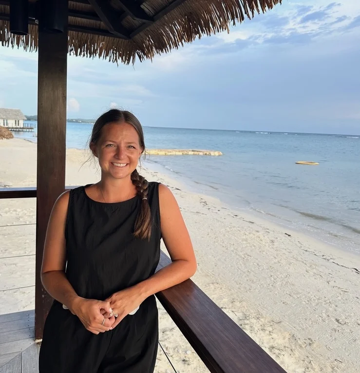 4737b702 61a4 4122 Af55 3339f98025db 1 105 C Woman smiling under a beach cabana by the ocean