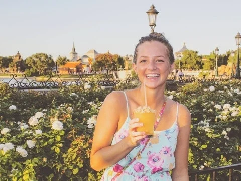 Elliott Hogan, the travel advisor behind Hakuna MaTravels, smiling with a tropical drink
